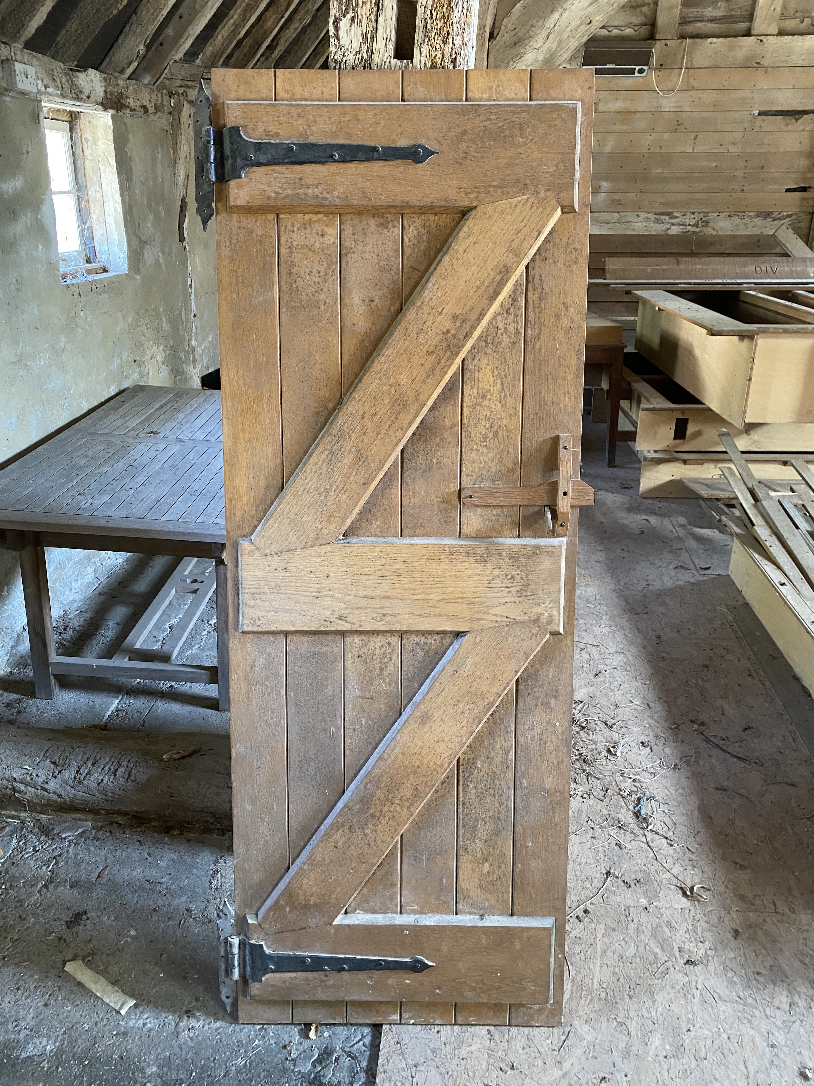 Three solid oak ledged and braced doors, 210 x 58.5cm; 204 x 44.5cm and 95 x 72cm, and a double sided panelled solid oak door, 200 x 64cm (4)